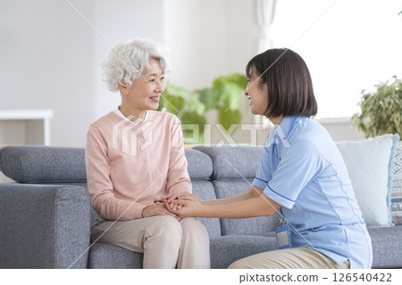 Smiling senior woman and care staff talking Smiling senior woman and care staff talking 126540422