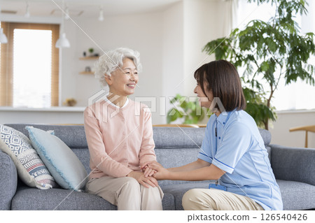 Smiling senior woman and care staff talking Smiling senior woman and care staff talking 126540426