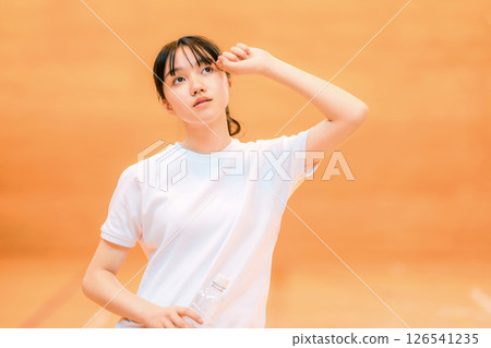 小學、國中和高中的女生穿著運動服在體育館喝瓶裝水補充水分 126541235