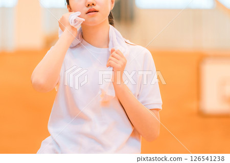 Elementary school, junior high school, and high school girls in gym clothes wiping sweat with a towel in the gym 126541238
