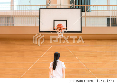 Junior high school and high school girls in gym clothes playing basketball in a gymnasium Junior high school and high school girls in gym clothes playing basketball in a gymnasium 126541773
