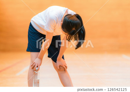 小學、國中和高中女生穿著運動服,在體育館裡努力訓練,疲憊不堪 小學、國中和高中女生穿著運動服,在體育館裡努力訓練,疲憊不堪 126542125