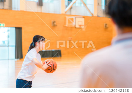 體育館裡，身著運動服、手拿籃球的女國中生和女高中生，以及一名男老師 126542128