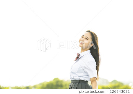 Smiling high school girl looking up at the sky 126543021