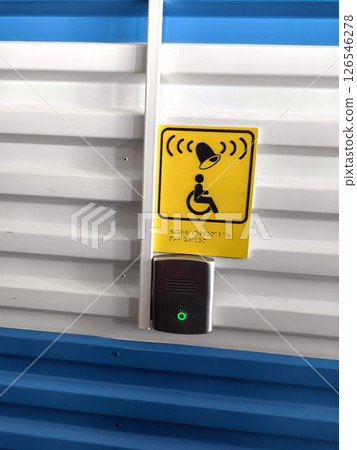 accessibility assistance button displayed on wall in public area bright blue background. closeup. 126546278