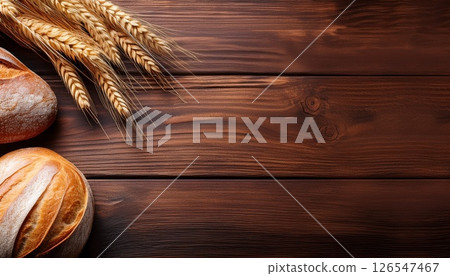 小麥和新鮮出爐的麵包在木紋上閃閃發光，複製空間 2 126547467