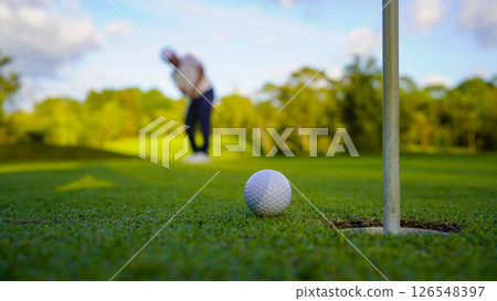 Golfers are putting golf in the evening golf course golf backglound. Golfers are putting golf in the evening golf course golf backglound. 126548397