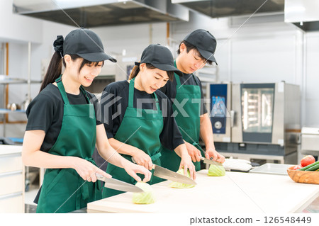 Male and female kitchen staff cutting cabbage in the kitchen 126548449