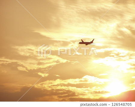 Silhouette of an airplane flying in the sunset Silhouette of an airplane flying in the sunset 126548705