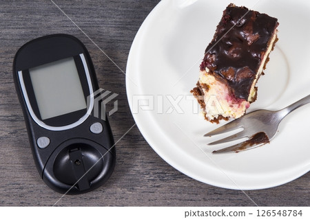 Glucose meter for measuring sugar level and cheesecake with cherries and chocolate Glucose meter for measuring sugar level and cheesecake with cherries and chocolate 126548784