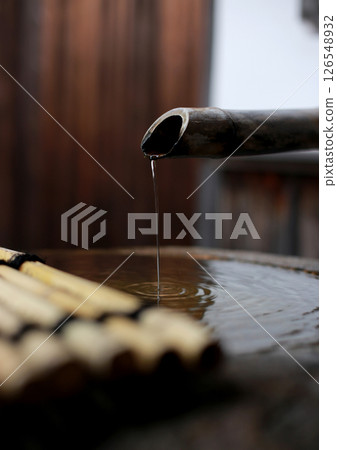 Water dripping from bamboo pipe into stone basin in japanese garden Water dripping from bamboo pipe into stone basin in japanese garden 126548932