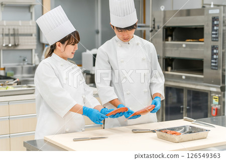 身穿廚師服的男女工作人員煮魚(廚師、職業學校、廚師、菜市場、食物加工) 身穿廚師服的男女工作人員煮魚(廚師、職業學校、廚師、菜市場、食物加工) 126549363