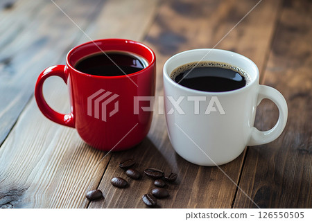 Two ceramic mugs, one red and one white, sit side by side on a wooden table, with a softly blurred background featuring brick walls and greenery. Two ceramic mugs, one red and one white, sit side by side on a wooden table, with a softly blurred background featuring brick walls and greenery. 126550505