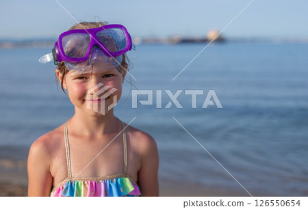 Young girl with goggles at the beach smiling on a sunny day 126550654
