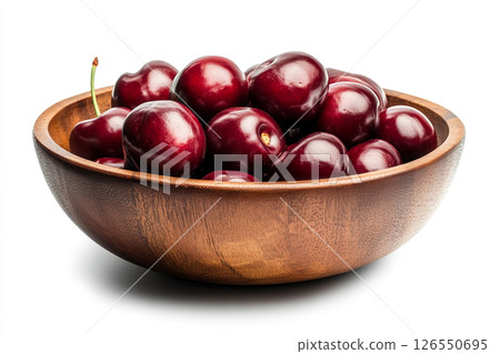 A wooden bowl filled with fresh, dark red cherries, each covered in water droplets, creating a visually appealing and appetizing image. 126550695