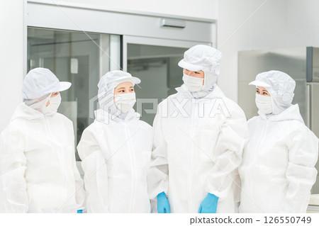 Male and female staff working in a manufacturing plant wearing protective clothing and clean wear Male and female staff working in a manufacturing plant wearing protective clothing and clean wear 126550749