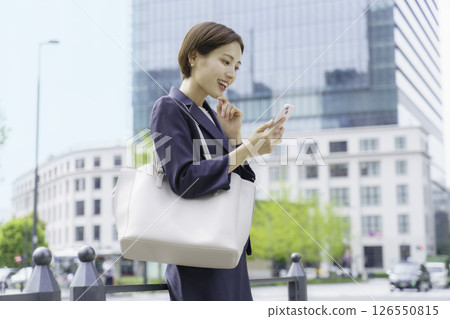 A young business woman searching on her smartphone in front of Tokyo Station 126550815