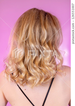 An elegantly captivating portrait showcasing stunning blonde curly hair from the back side 126551007