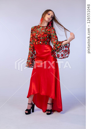 An Elegant Red Evening Dress with Floral Details and Stylish Accessories enhancing the look 126551048