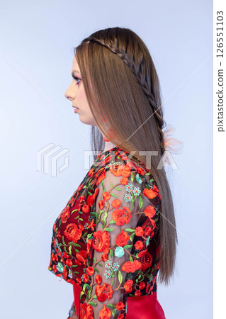An Elegant Model Dressed in a Beautiful Floral Dress with Gorgeous Long Hair Flows Gently An Elegant Model Dressed in a Beautiful Floral Dress with Gorgeous Long Hair Flows Gently 126551103