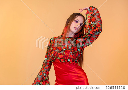An Elegant Fashion Model in Beautiful Floral Attire Against a Bright Orange Background An Elegant Fashion Model in Beautiful Floral Attire Against a Bright Orange Background 126551118