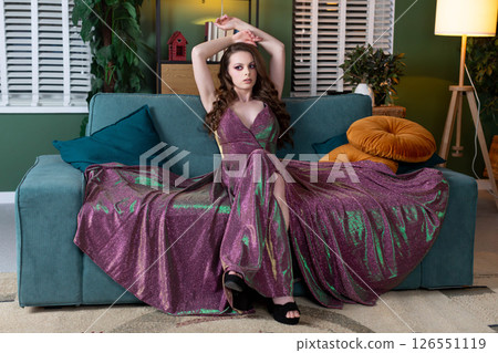 An Elegant Fashion Model in a Beautifully Flowing Dress Posing Gracefully on a Sofa An Elegant Fashion Model in a Beautifully Flowing Dress Posing Gracefully on a Sofa 126551119