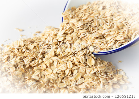 Oatmeal oat spilling from the bowl Blue-rimmed bowl and oatmeal rolled oats 126551215