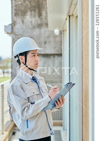 一名年輕的男建築工人在檢查某件東西 126551261