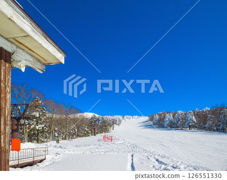 A ski resort on a clear day with a view of the distant mountain peaks (Yamagata Prefecture, Zao Onsen Ski Resort, Utopia Slope) 126551330