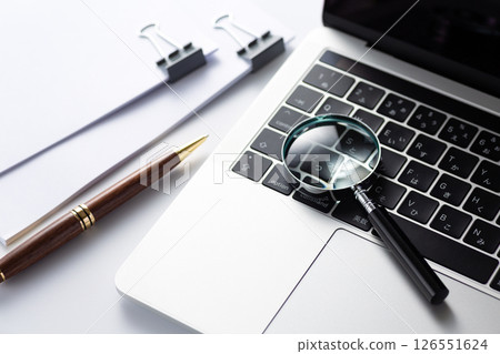 Documents clipped with a magnifying glass 126551624