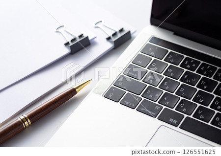 Documents clipped together and a computer 126551625