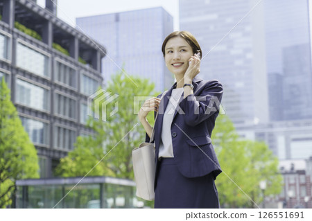 一位年輕女商人在辦公區用智慧型手機聊天 126551691