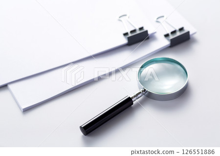Documents clipped with a magnifying glass 126551886