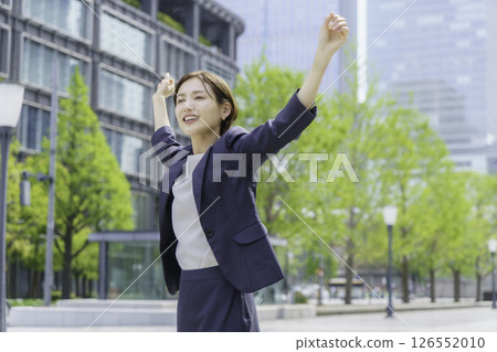 Young businesswoman stretching outdoors 126552010