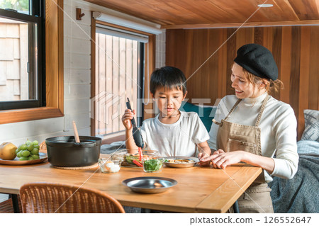 Family staying in a bungalow/cottage and preparing meals together (family trip/glamping) 126552647
