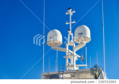 KNS ship's navigation and communication equipment under a clear blue sky. Satellite antennas, weather monitors, and GPS gear in view KNS ship's navigation and communication equipment under a clear blue sky. Satellite antennas, weather monitors, and GPS gear in view 126552663
