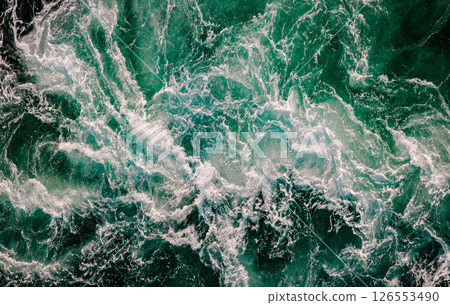Blue waves of water of the river and the sea meet each other during high tide and low tide. Blue waves of water of the river and the sea meet each other during high tide and low tide. 126553490