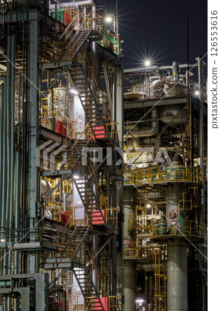 The night view of the Kawasaki factory, with its rusted exterior walls and solid structure 126553616