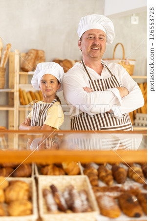 Dad and little daughter work sell in family bakery shop Dad and little daughter work sell in family bakery shop 126553728
