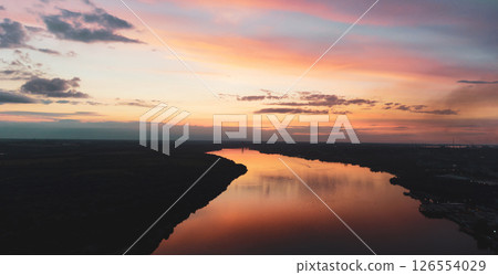 sunset with clouds, light rays over river with reflections 126554029