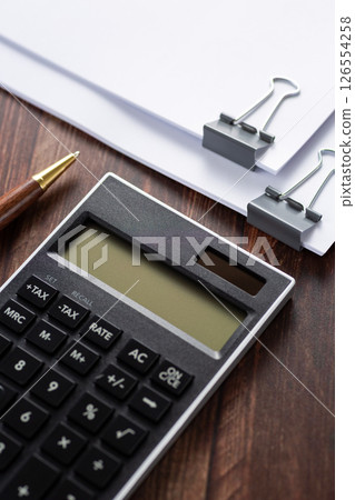 Documents and calculator clipped together Documents and calculator clipped together 126554258