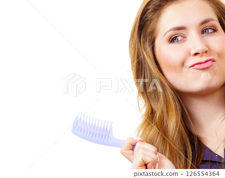 Woman long healthy brown hair holds comb 126554364