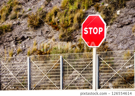 Stop sign by the road in mountains 126554614