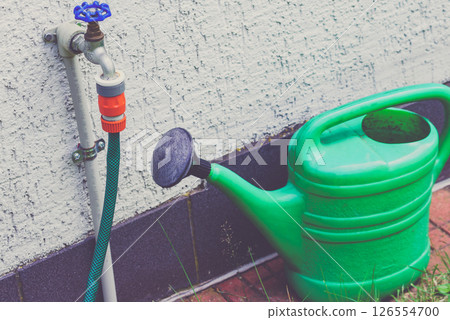 Watering green can on garden plot Watering green can on garden plot 126554700