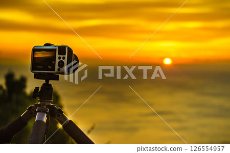 Camera taking picture film of sunrise over sea surface Camera taking picture film of sunrise over sea surface 126554957