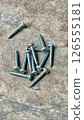 screws on ground, shiny metal screws scattered on a rough 126555181