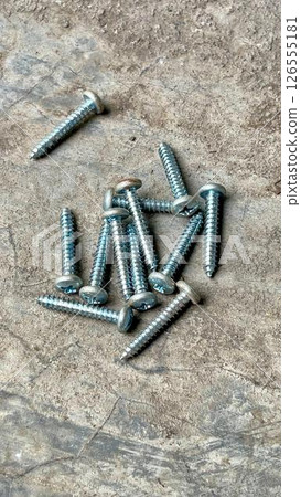 screws on ground, shiny metal screws scattered on a rough screws on ground, shiny metal screws scattered on a rough 126555181