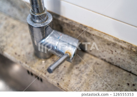 Dirty kitchen sink faucet contaminated with calcium and dirt. Dirty kitchen sink faucet contaminated with calcium and dirt. 126555353