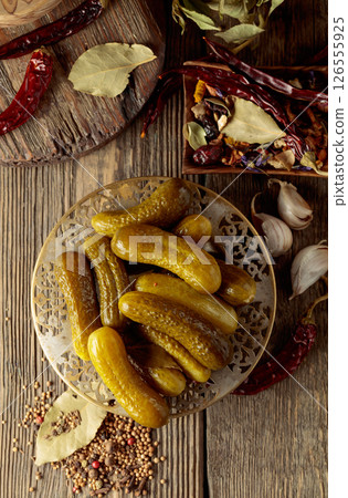 Pickled cucumbers with ingredients on an old wooden table. Pickled cucumbers with ingredients on an old wooden table. 126555925