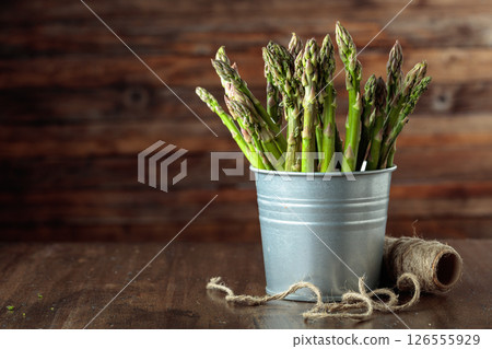 Fresh asparagus in small bucket on a old wooden table. Fresh asparagus in small bucket on a old wooden table. 126555929